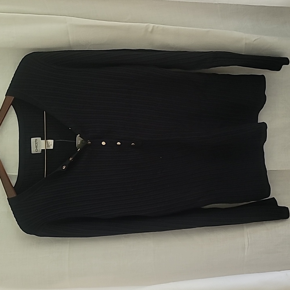 A black sweater with golden snaps